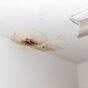Dark ceiling stain after rain caused by roof leak