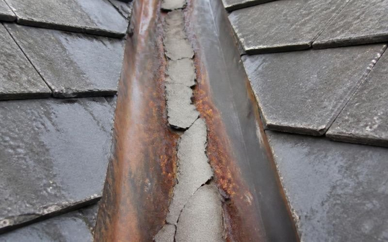 Failed sealant patch over a rusted valley iron